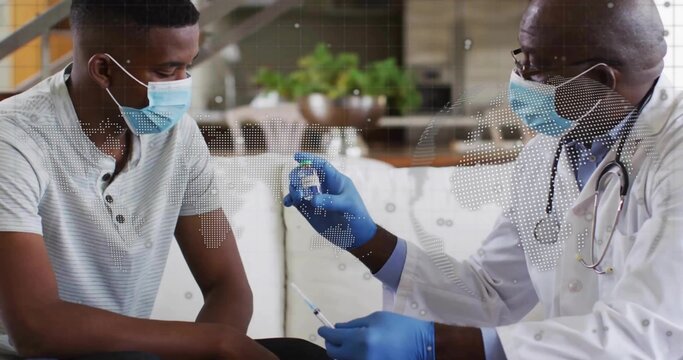 Patient sitting on couch at home wearing surgical mask, with doctor holding vaccine vial syringe