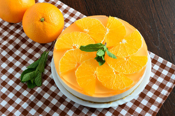 Delicious Orange Cheesecake with Fresh Mint Garnish on checkered tablecloth