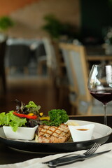 Delicious Grilled Steak Dinner with a Glass of Wine on Table