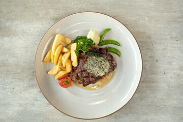 Deliciously cooked steak and fries meal, a perfect dish to enjoy. The meal includes a juicy steak, golden fries, and a mix of fresh vegetables
