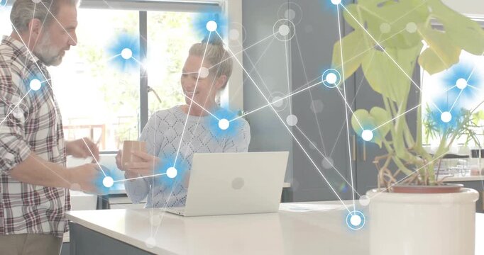 Man entering kitchen placing mug beside laptop user sharing coffee while graphic overlay animating