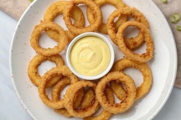 Crispy golden onion rings served with a creamy dipping sauce display