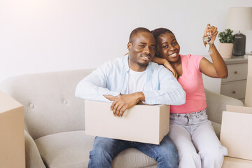 African couple celebrating moving day holding new home keys