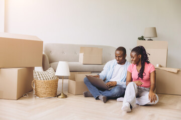 African American couple planning moving day, using laptop
