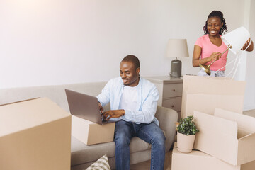 African couple moving to new home unpacking boxes