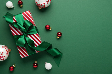 Merry Christmas and Happy Holidays greeting card, frame, banner. New Year. Red Christmas ornaments and gifts, presents on green background top view. Xmas holiday festive theme. Christmas decoration