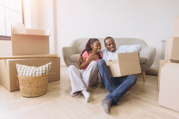 African couple moving to new home unpacking boxes