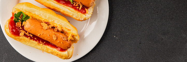 Hotdog fried onions, sausage, bun, sauce fast food tasty snack fresh delicious gourmet food background on the table rustic top view copy space