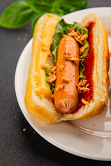 Hotdog fried onions, sausage, bun, sauce fast food tasty snack fresh delicious gourmet food background on the table rustic top view copy space