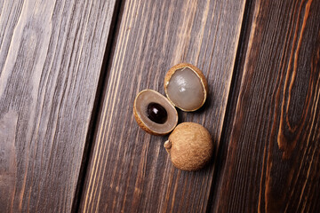 Longan tropical fruit displayed on wooden surface, showcasing its unique texture and color, emphasizing freshness and natural beauty in a vibrant setting