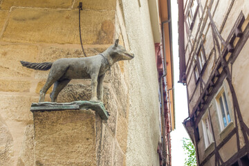Historische Skulptur eines angeleinten Wolfes mit gestreckter Rute auf Konsole an Tragstein eines mittelalterlichen Hauses in Esslingen am Neckar