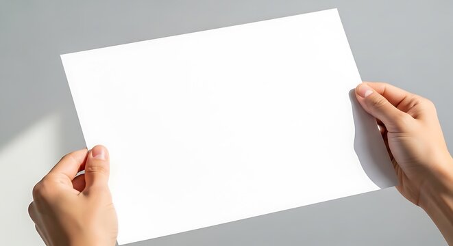 Hands holding a blank sheet of paper, offering a canvas for creativity and communication, perfect for showcasing designs, messages, or announcements