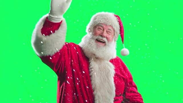 Cheerful santa claus with a white beard and red suit, waving his hand with a warm smile on green screen