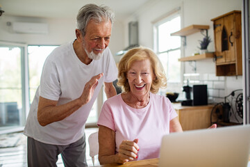 Senior couple video chatting at home