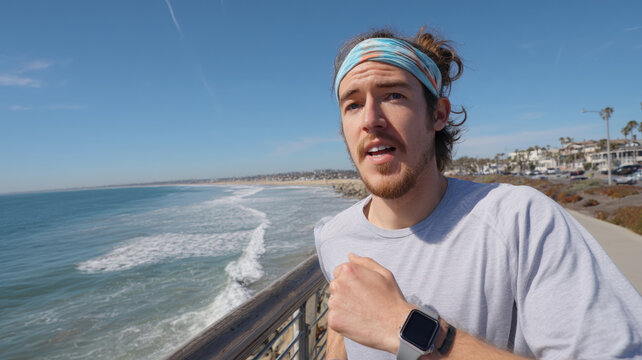 Runner with Headband and Smartwatch Jogging Along Scenic Shoreline - Powered by Adobe