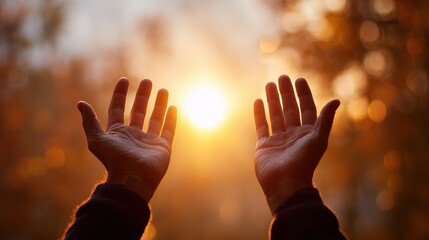 Silhouetted hands of a deity against a blurred autumn sunset