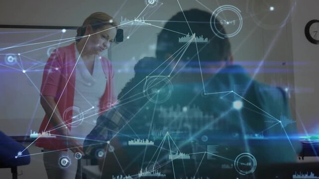 Teacher approaching male student writing in classroom offering guidance while network lines pulsing - Powered by Adobe