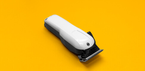 Hairdressing and barber tools. Professional hairdressing clipper. Bright yellow background. The concept of hair care and professional grooming. Copy space for marketing.