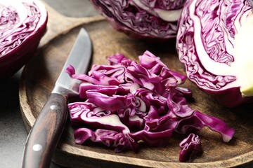 Cut red cabbage and knife on grey table, closeup
