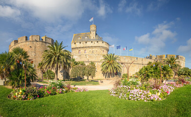 Vieux chateau sous un ciel bleu entouré de vegetation, l'hotel de ville de saint malo en Bretagne