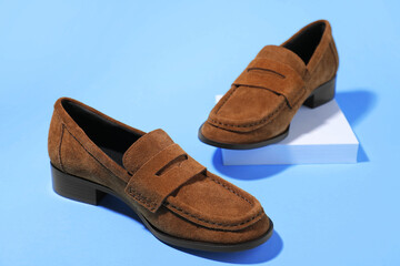 Naklejka premium Pair of stylish brown shoes on light blue background, closeup