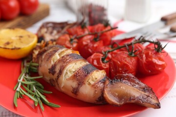 Tasty stuffed squid, rosemary, lemon and tomatoes on light table, closeup