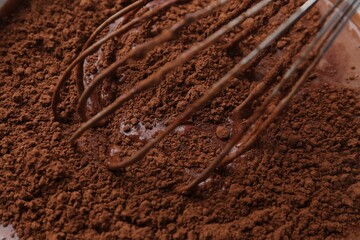 Adding cocoa powder into bowl with dough, closeup
