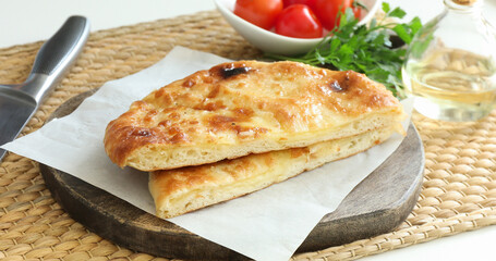 Pieces of delicious Megrelian khachapuri and products on table, closeup