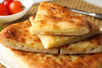 Pieces of delicious Megrelian khachapuri and products on table, closeup