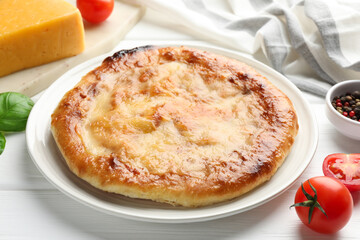 Delicious Megrelian khachapuri and products on white wooden table, closeup