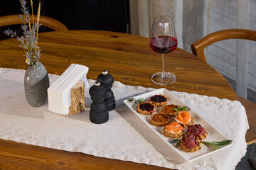 An Elegant Table Setting with a Variety of Appetizers Accompanied by Fine Red Wine Choices