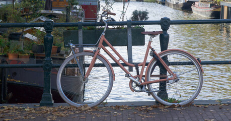 Obraz premium Vintage bicycle parked by a canal in Amsterdam, Netherlands