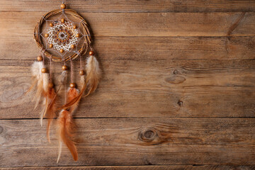 Beautiful dream catcher on wooden background, top view. Space for text