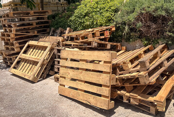 Wooden pallets stacked in a market area, showcasing a vibrant street market atmosphere.