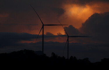 Two Wind Turbines under Storm Cloud Sunset