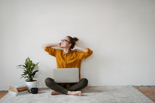 Young female student studying, working on laptop.