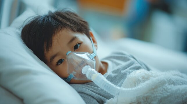 An Asian toddler boy is ill with respiratory issues and requires nebulization therapy while resting in a hospital bed