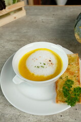 Delicious creamy pumpkin soup, a culinary delight, accompanied by toasted garlic bread and garnished with parsley, a treat for the senses