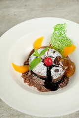 A delicious chocolate lava cake, garnished with cherry and mint, on a plate