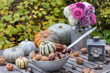 Herbst-Arrangement mit Nüssen im alten Durchschlag, Kürbissen und Dahlienstrauß