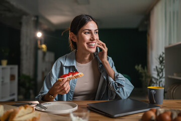 Woman multitasking, eating breakfast and talking on phone