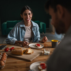 Couple enjoying healthy breakfast together talking at home
