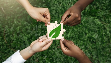 Diverse hands unite to assemble a green leaf puzzle symbolizing environmental collaboration and growth
