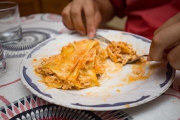 Detalhe de refeição de lasanha de atum a ser degustada. 