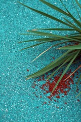 Grass blades over textured blue ground with spilled brown granules