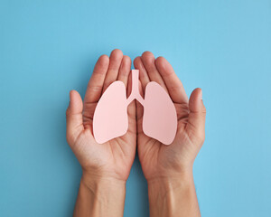 Gentle hands cradling a delicate paper lung cutout symbolize health awareness and respiratory care beautifully