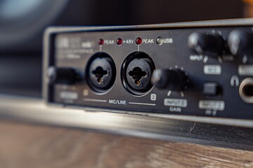 Detailed view of an audio interface showing microphone inputs, gain controls, and indicator lights, ideal for music production.