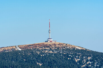 Praděd mountain in Jesen&iacute;ky, Czech Republic, with the iconic TV tower rising above a snowy winter landscape under a clear blue sky.