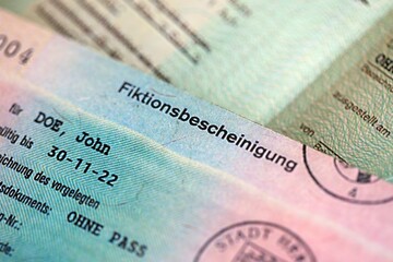 German temporary Permanent resident card specimen lies on wooden table close up. Fiktionsbescheinigung