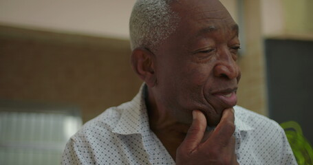 Elderly African American man sneezing into his hand, capturing a moment of vulnerability and...